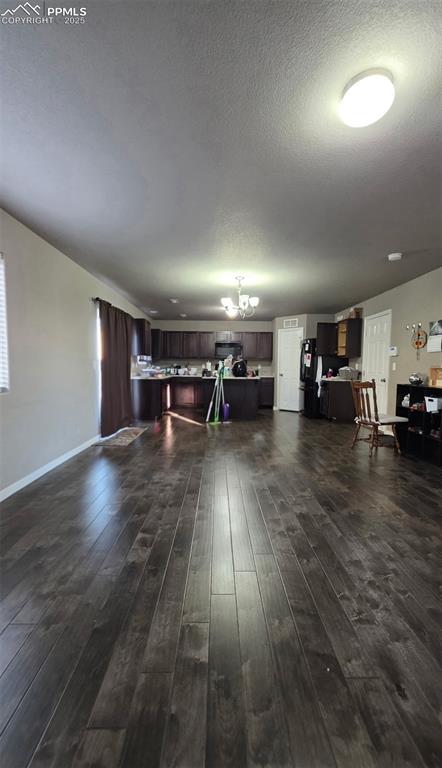 Image 2 of 8: Living room featuring a textured ceiling, dark wood-style flooring, and a c