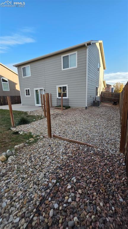 Image 6 of 8: Rear view of house featuring a fenced backyard and a patio area