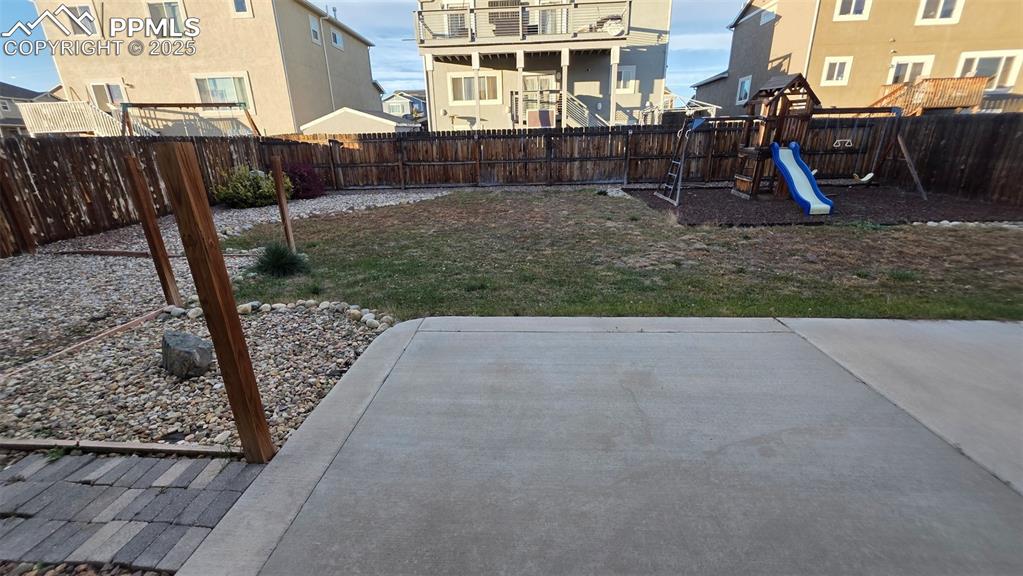 Image 8 of 8: Fenced backyard featuring a playground and a residential view
