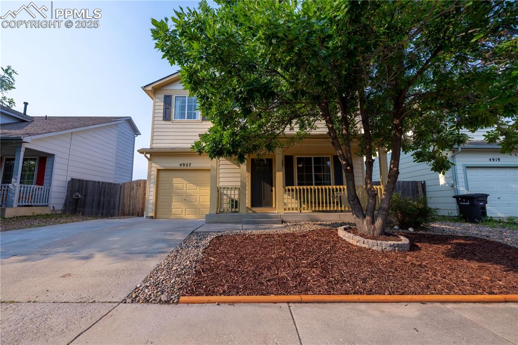 Image 2 of 42: Obstructed view of property with covered porch, driveway, and an attached g