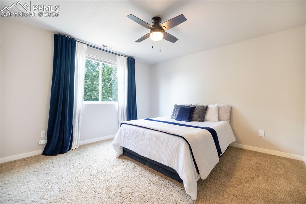 Image 21 of 42: Carpeted bedroom with baseboards and ceiling fan