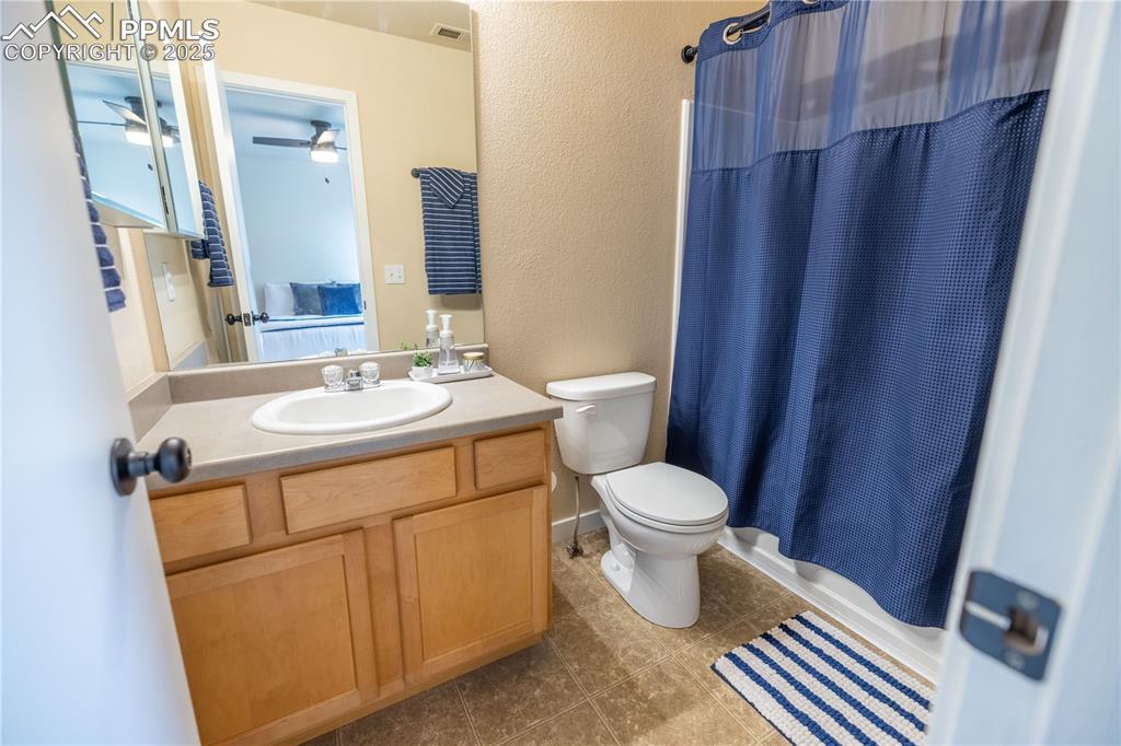Image 24 of 42: Full bath featuring vanity, tile patterned flooring, a textured wall, showe