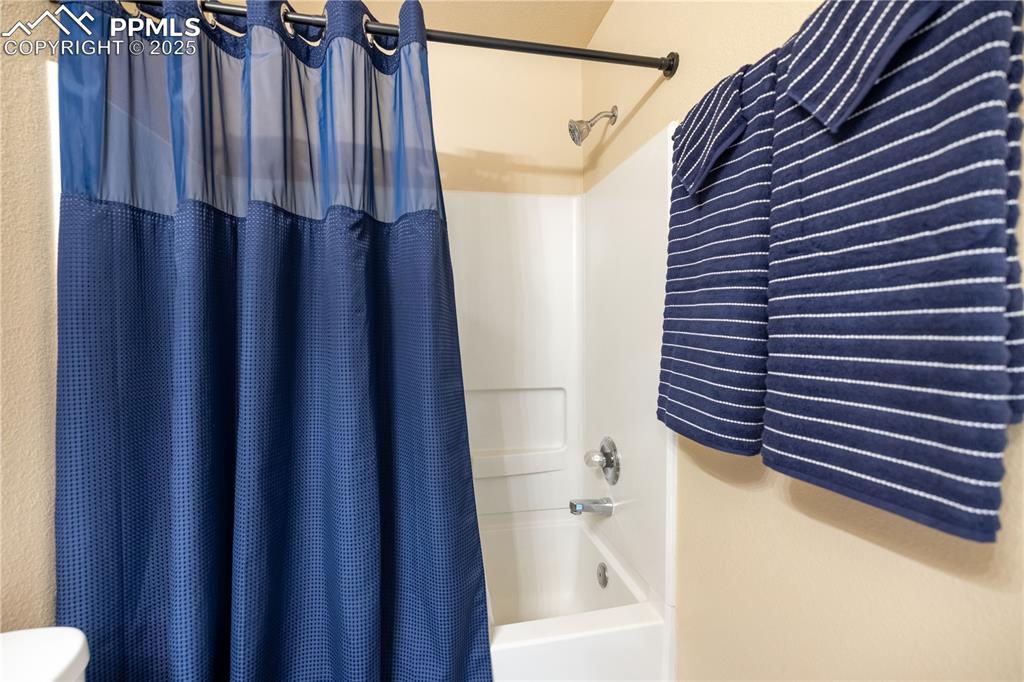 Image 26 of 42: Full bathroom featuring shower / bath combination with curtain and toilet