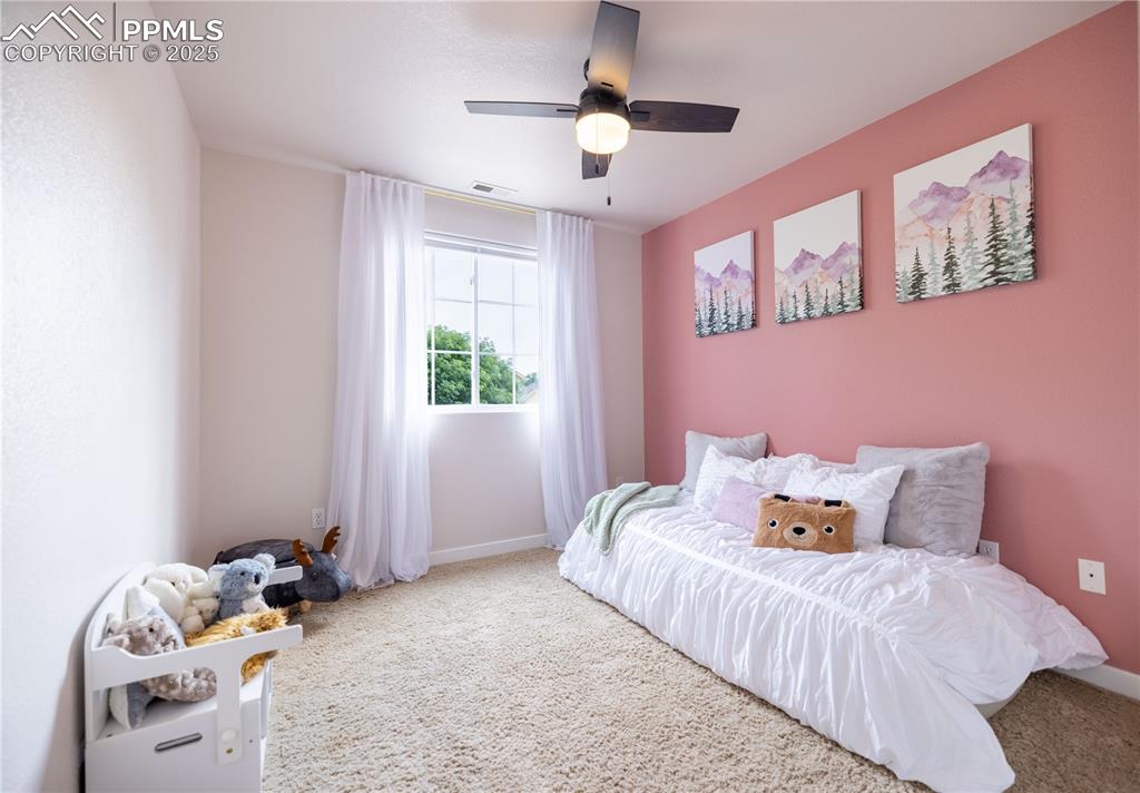 Image 28 of 42: Carpeted bedroom with baseboards and ceiling fan