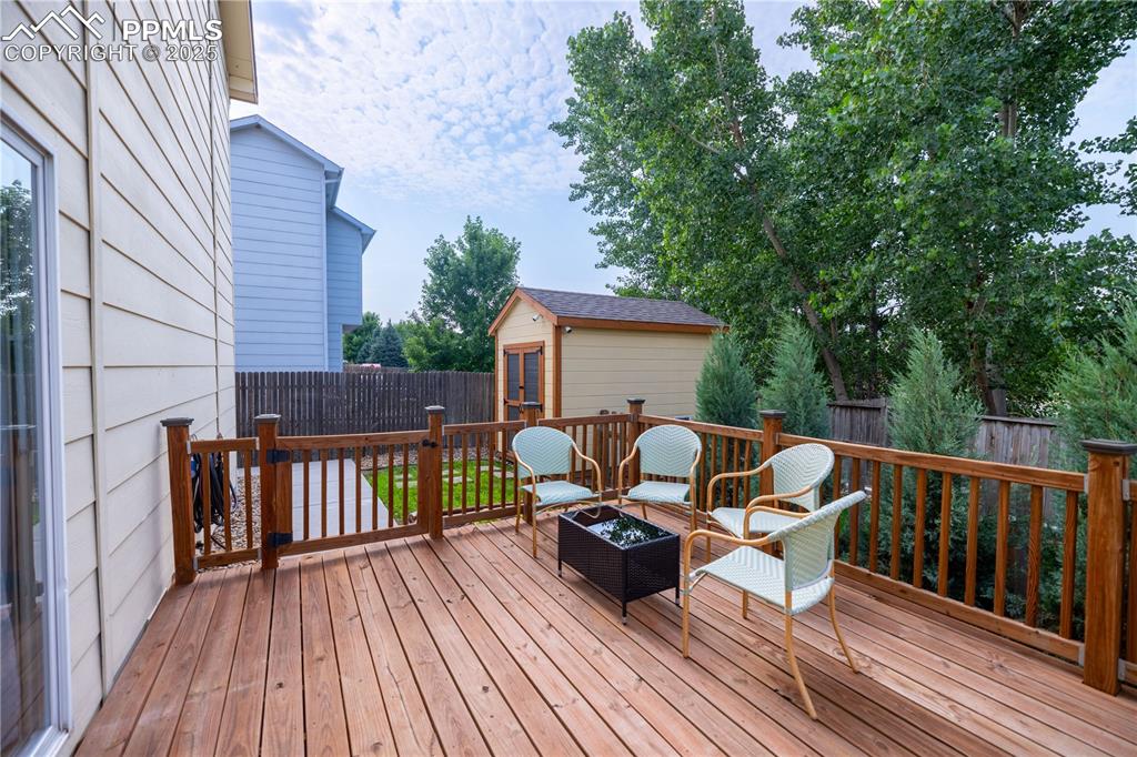 Image 33 of 42: Deck with an outdoor structure, a fenced backyard, and an outdoor fire pit