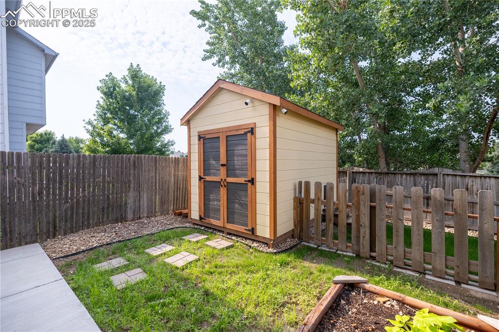 Image 36 of 42: View of shed with a fenced backyard