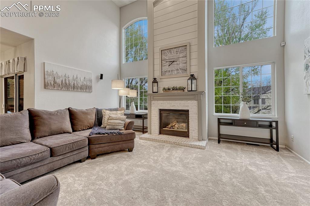 Image 12 of 48: Beautiful fireplace focal point & 2-story windows