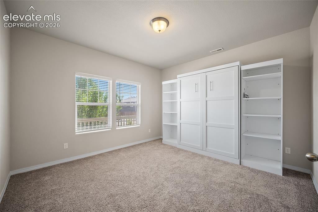 Image 16 of 46: Office with Murphy Bed and built in shelving