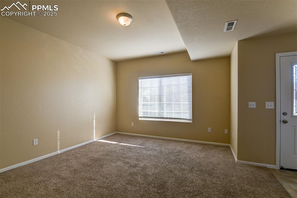 Image 13 of 33: Carpeted spare room featuring baseboards and a textured ceiling