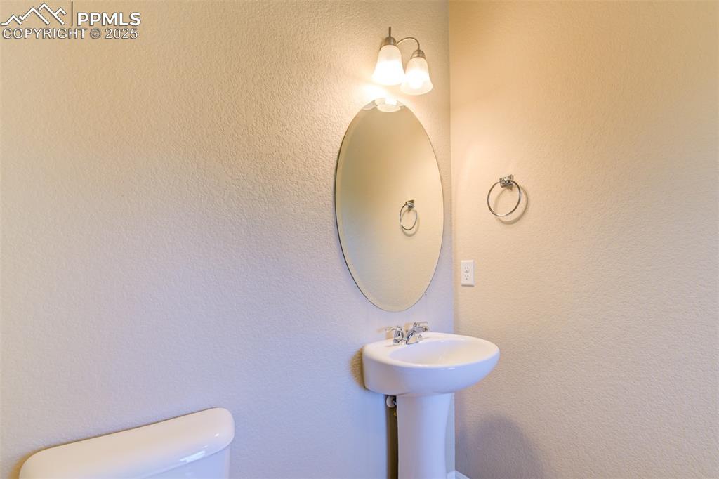 Image 17 of 33: Half bathroom with a textured wall and toilet