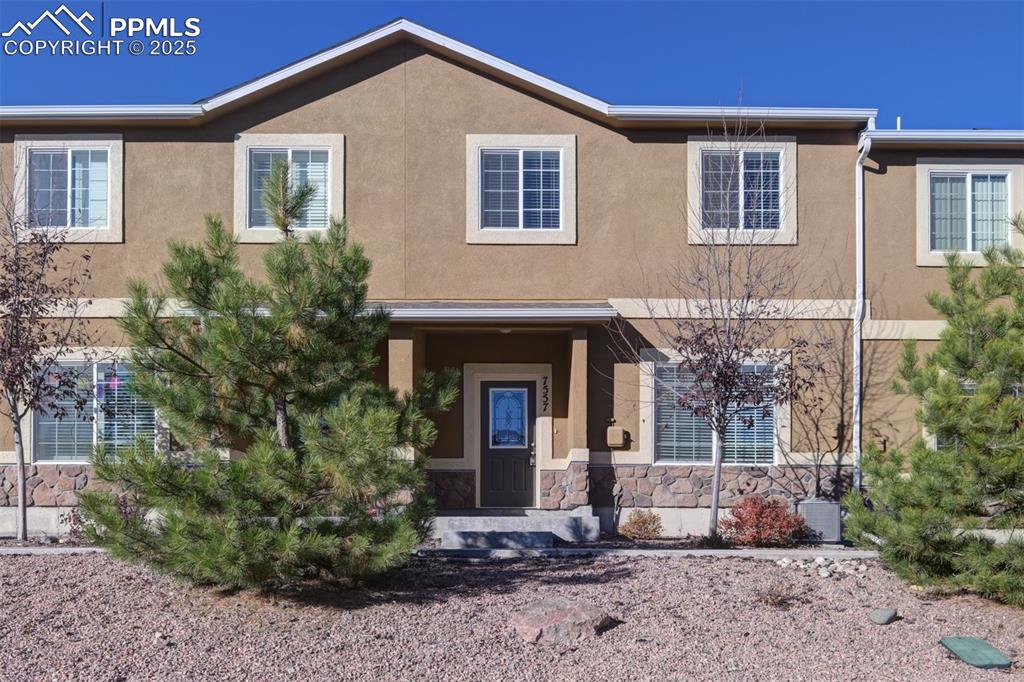 Image 2 of 33: View of front of property with covered porch, stucco siding, and stone sidi