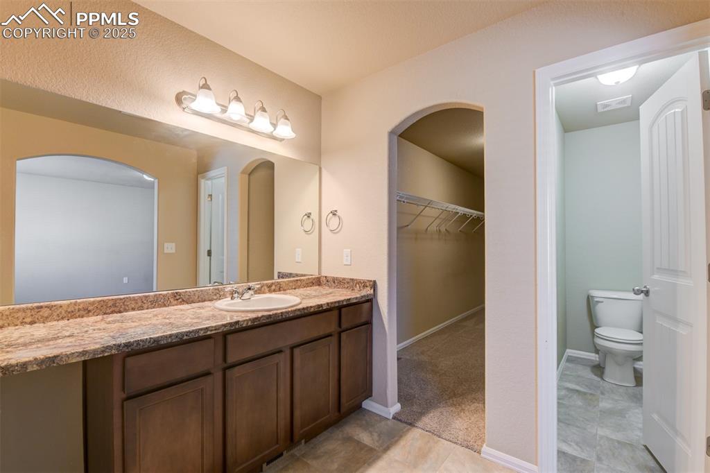 Image 22 of 33: Full bathroom featuring vanity and a walk in closet