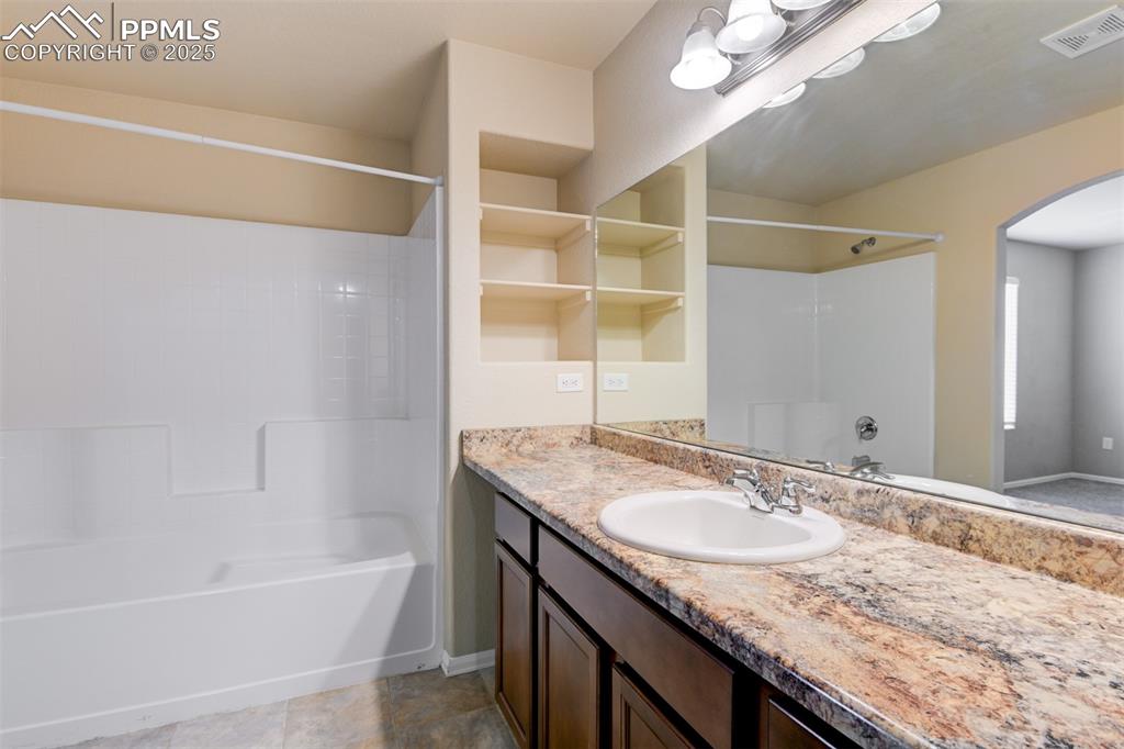Image 23 of 33: Bathroom with shower combination and vanity