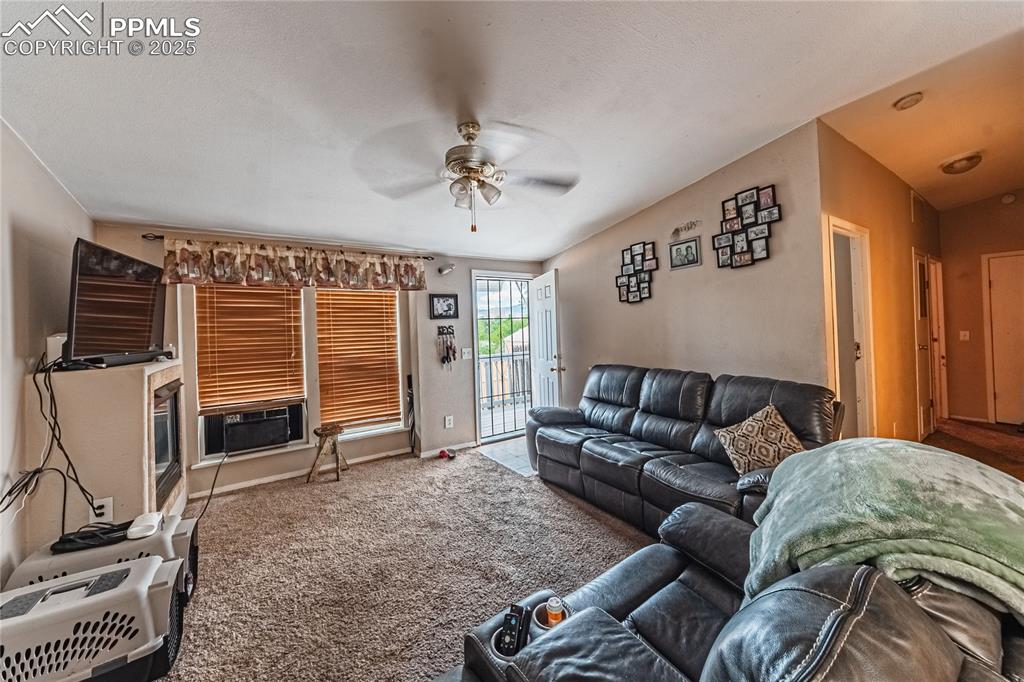 Image 31 of 42: Carpeted living room featuring a ceiling fan and cooling unit