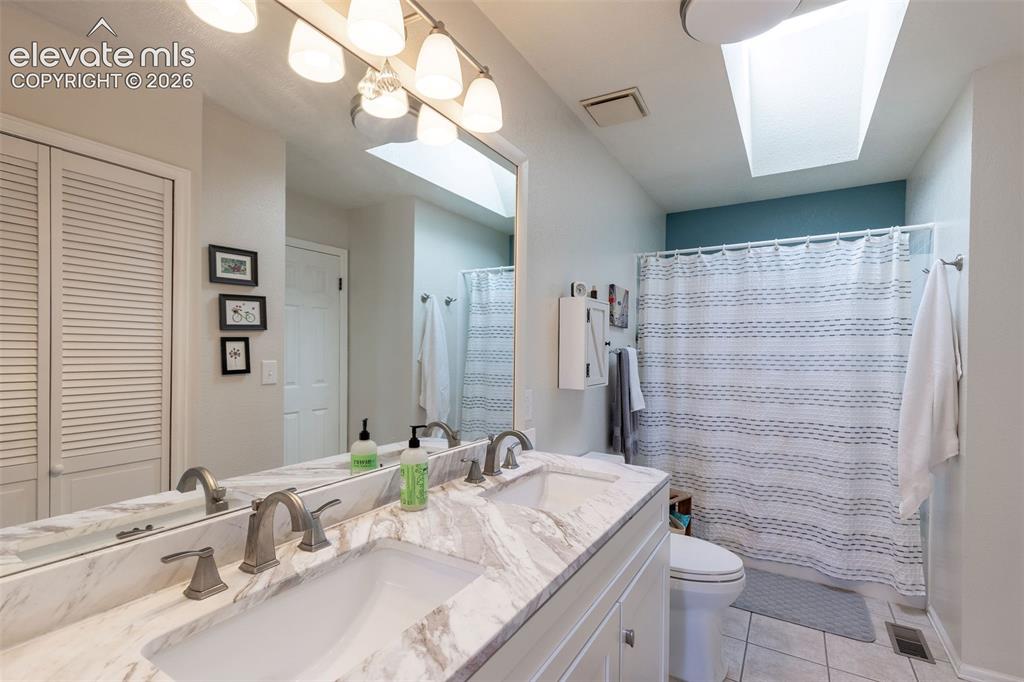 Image 15 of 24: Double vanity with stone-finish countertop