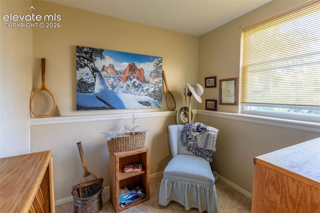 Image 16 of 24: Room featuring light beige walls with white trim, a window with horizontal