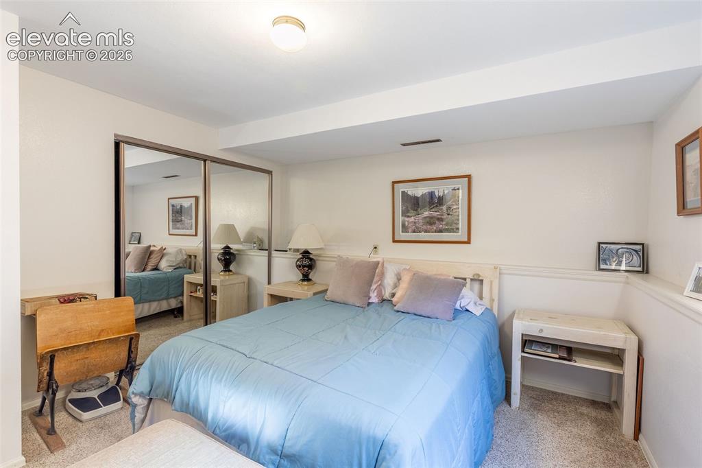 Image 17 of 24: Bedroom featuring wall-to-wall carpeting, mirrored closet doors, a built-in