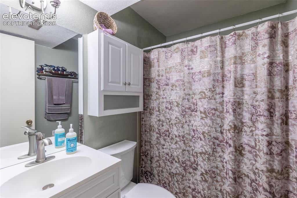 Image 18 of 24: Bathroom featuring a white vanity with a single basin sink, brushed nickel