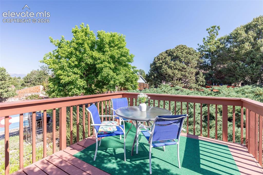 Image 20 of 24: Expansive outdoor deck featuring wood-finish flooring and a stained wood ra