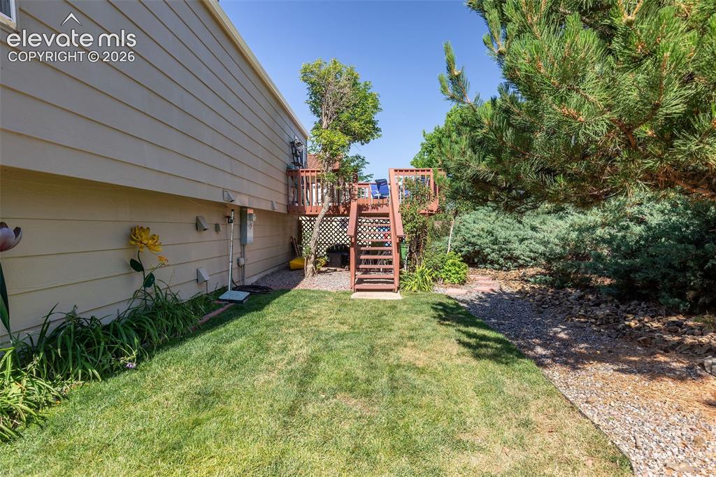 Image 21 of 24: Elevated wood deck with stairs offering access to the yard
