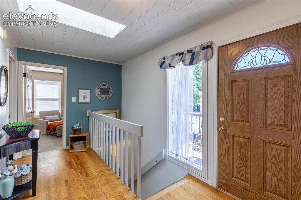 Image 6 of 24: Entryway featuring a wood-panel door with decorative arched glass, wood-fin