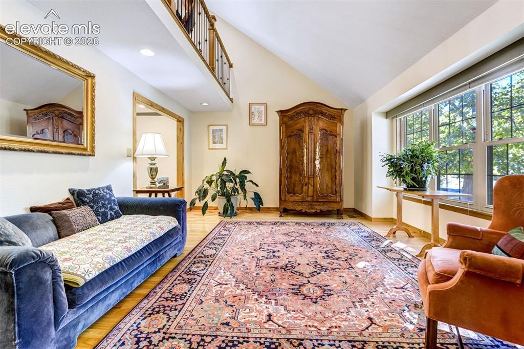 Image 10 of 50: Formal living room with vaulted ceiling and hardwood floors