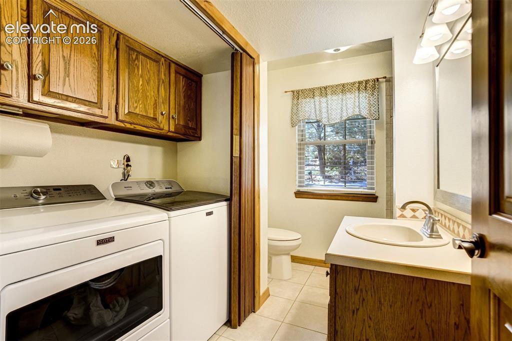 Image 34 of 50: Lower level laundry space and bath