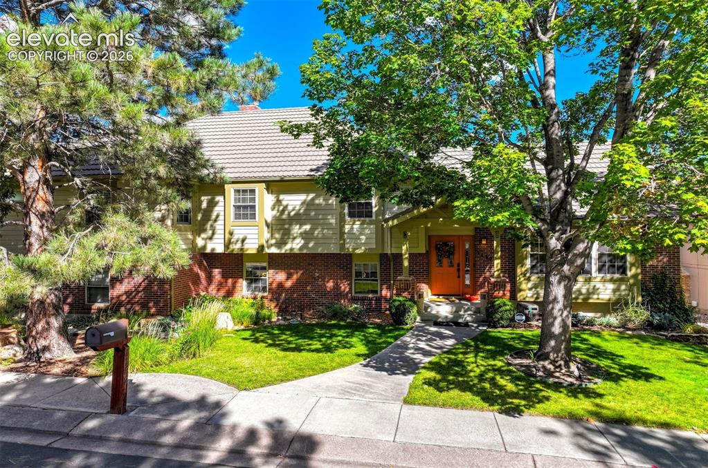Image 8 of 50: Rockrimmon home with professional landscaping throughout front and back yar