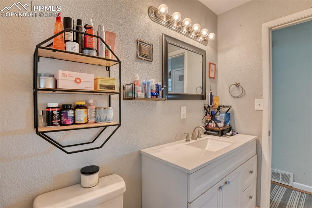 Image 17 of 45: Half bath featuring a textured wall and vanity