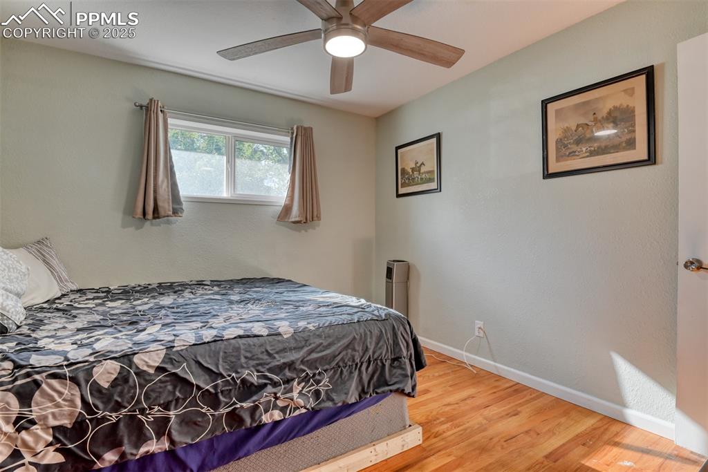 Image 22 of 45: Bedroom featuring wood finished floors, a ceiling fan, and a textured wall