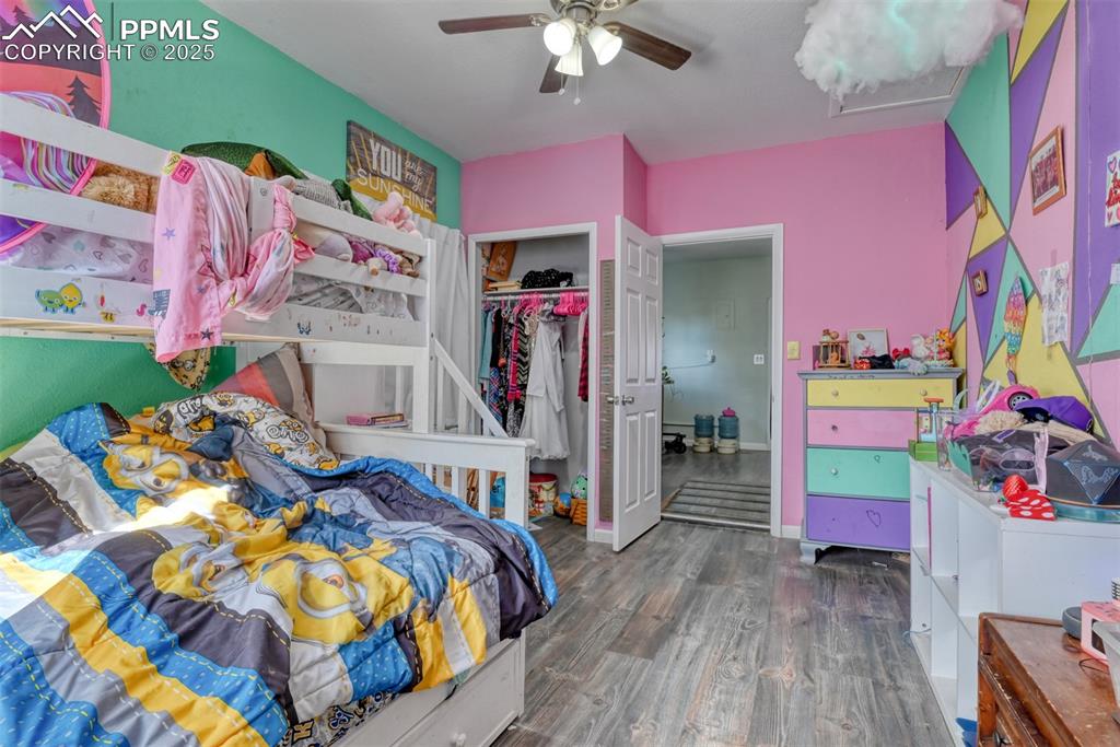 Image 27 of 45: Bedroom with dark wood-style floors, a ceiling fan, and a closet