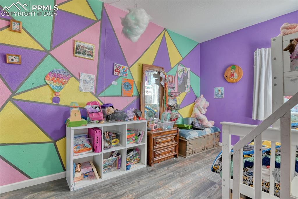Image 28 of 45: Bedroom with wood finished floors and baseboards