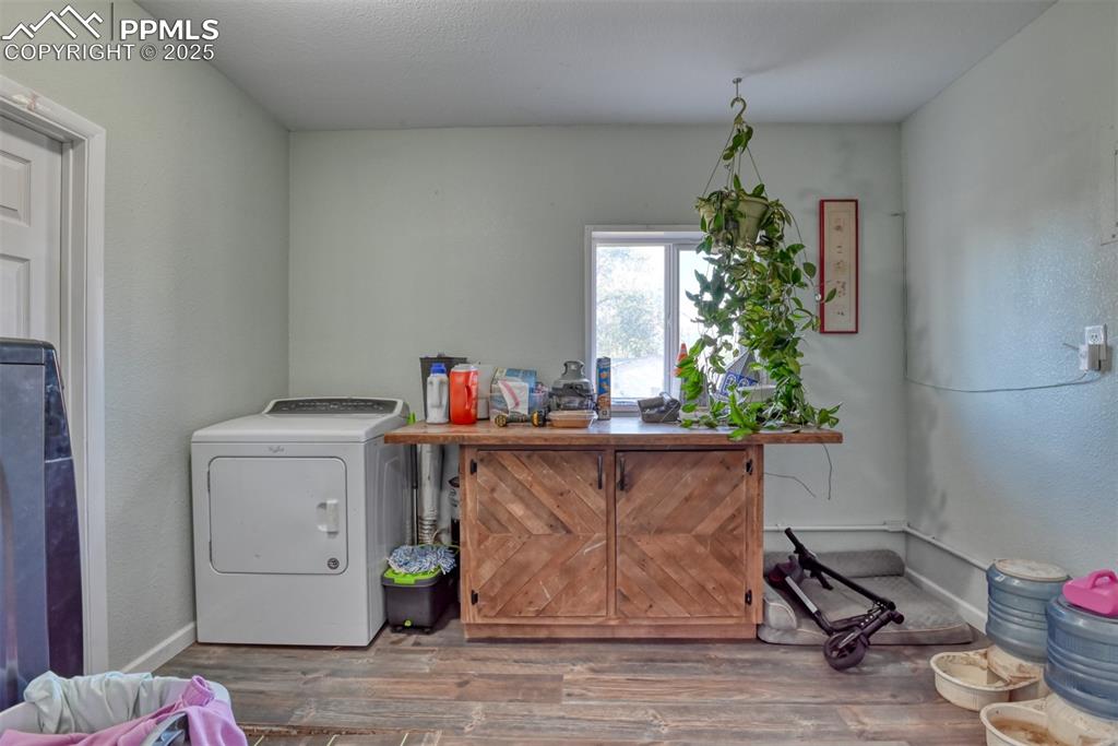 Image 34 of 45: Laundry room featuring wood finished floors and a textured wall