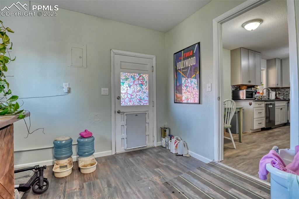 Image 35 of 45: Foyer with a textured wall and dark wood-style floors