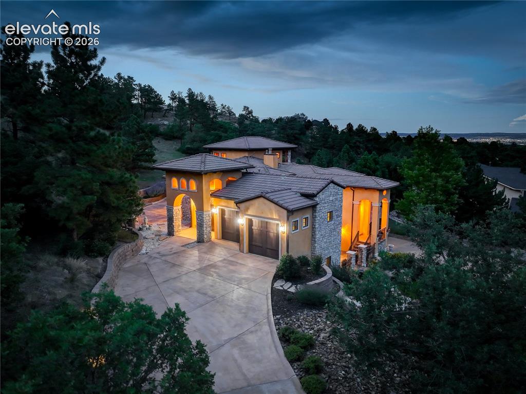 Image 46 of 50: View of residence, with twinkling city lights beyond.