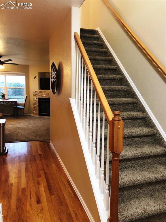 Image 13 of 26: Stairway featuring wood floor