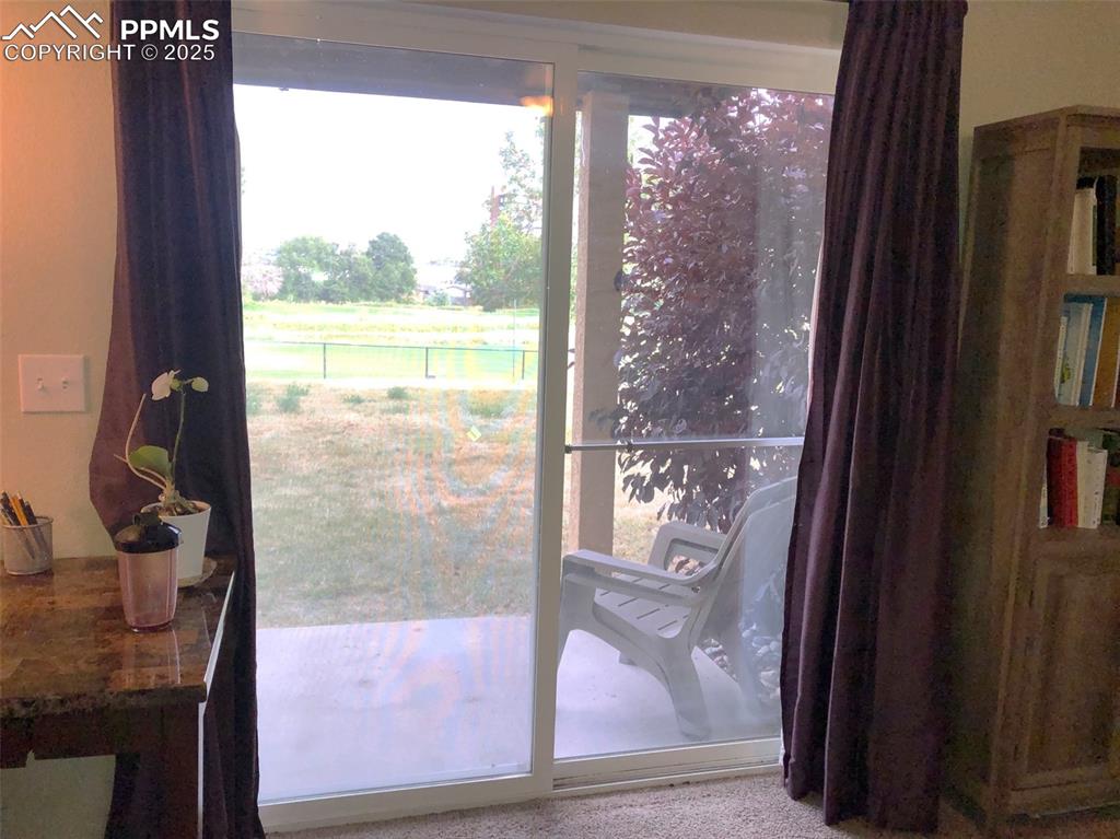 Image 22 of 26: Covered back porch, grassy area