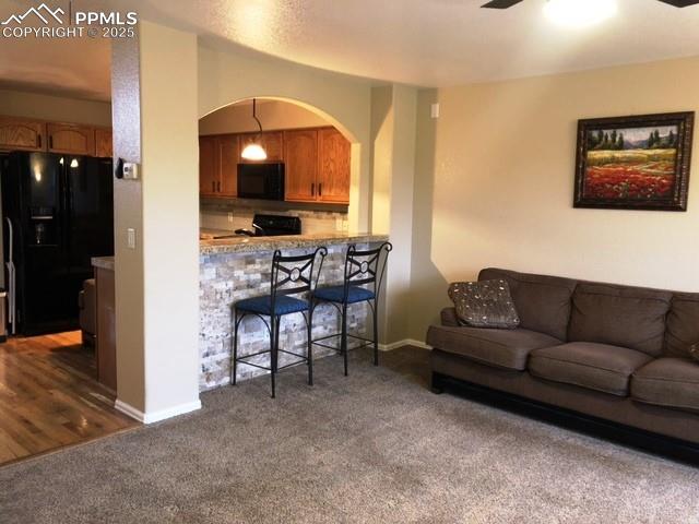 Image 5 of 26: Living room with carpet and ceiling fan