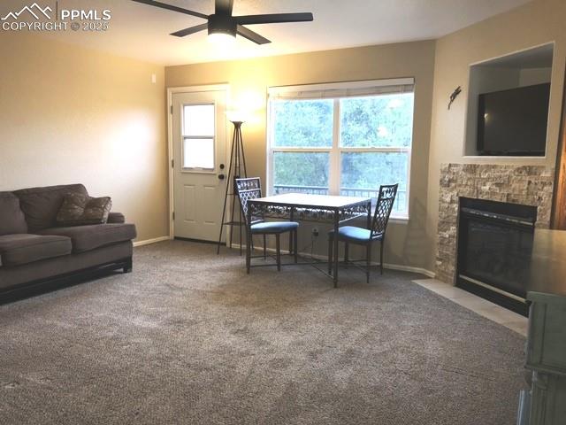 Image 6 of 26: Living room featuring carpet floors, a fireplace, and a ceiling fan