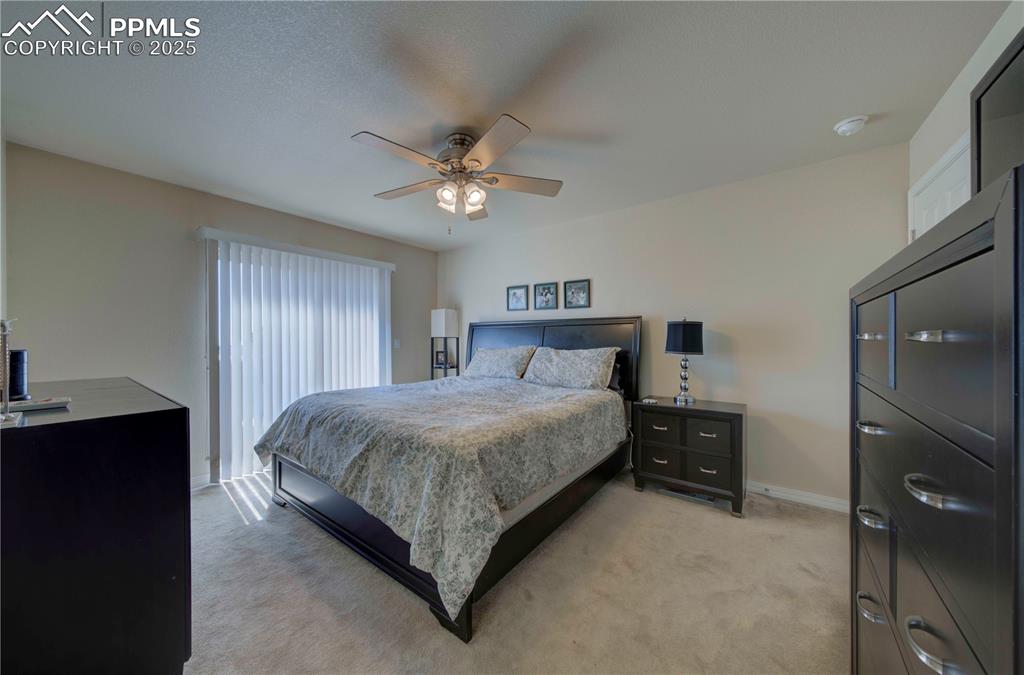 Image 20 of 49: Bedroom with light colored carpet and ceiling fan