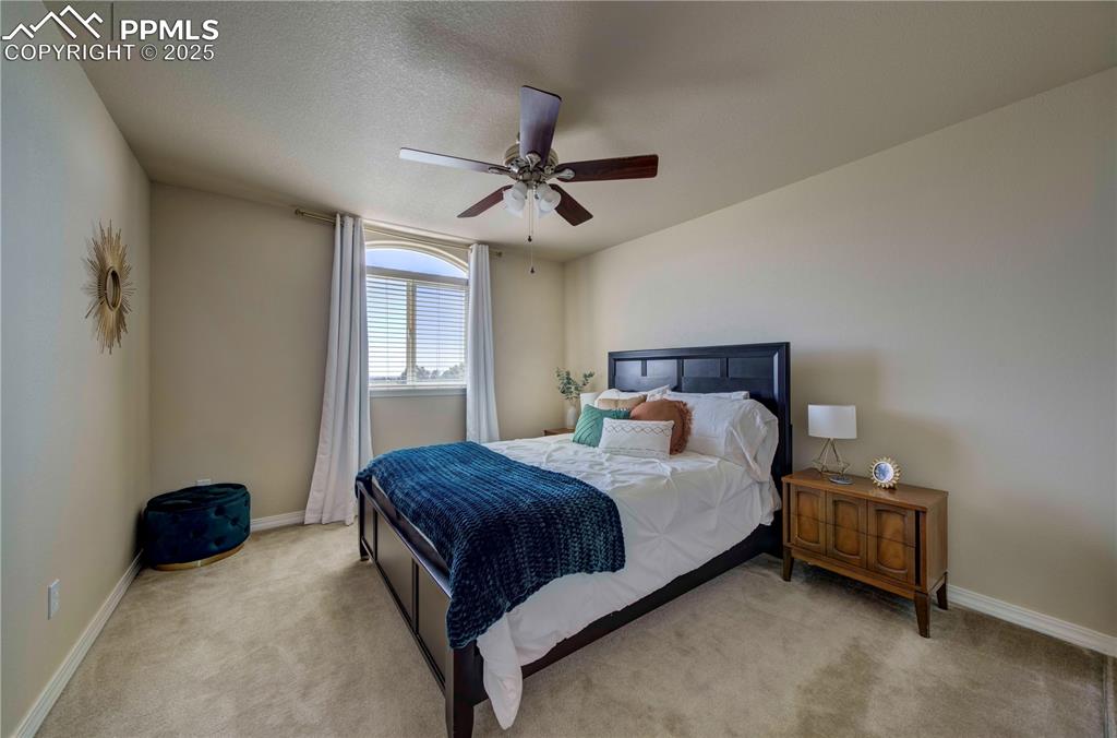 Image 34 of 49: Carpeted bedroom featuring a ceiling fan and a textured ceiling
