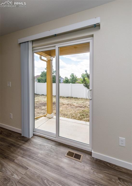 Image 11 of 45: Doorway to outside featuring wood finished floors