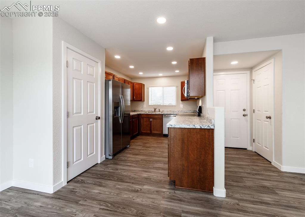 Image 13 of 45: Kitchen featuring dark wood-style floors, stainless steel appliances, reces