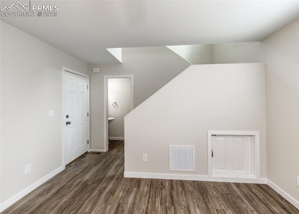 Image 21 of 45: Bonus room featuring dark wood finished floors and baseboards