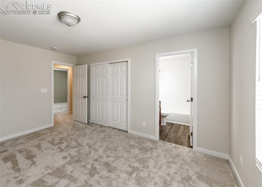 Image 25 of 45: Unfurnished bedroom featuring carpet, a closet, and ensuite bathroom
