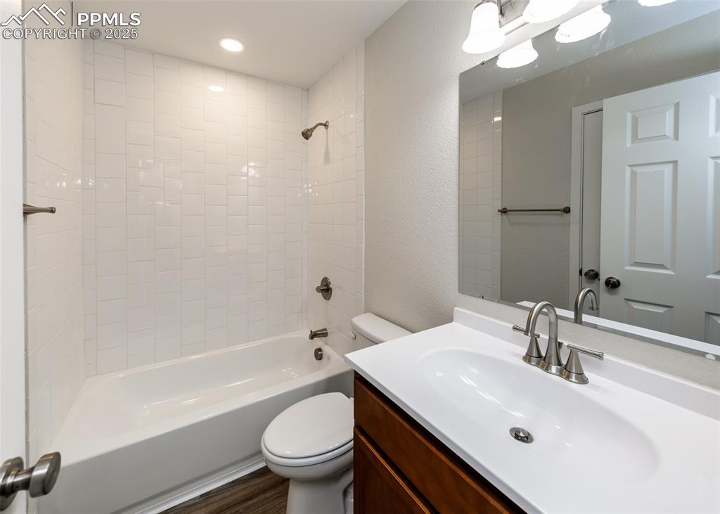 Image 36 of 45: Bathroom with  shower combination, vanity, a textured wall, and recessed li