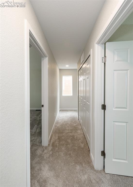 Image 41 of 45: Corridor with light carpet and baseboards