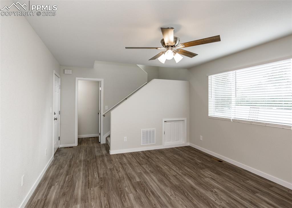 Image 5 of 45: Unfurnished living room featuring dark wood-style floors, a ceiling fan, an
