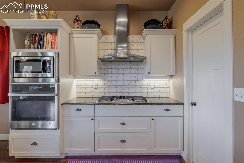 Image 10 of 49: Gas grill with a real vented hood to the outside. Pantry door is on the rig