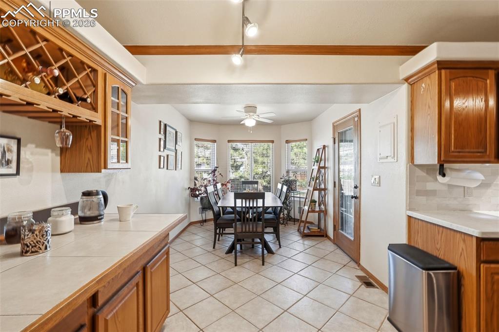 Image 10 of 50: Kitchen Built-Ins, Tile Floors, Bay Window In Dining Area, Glass Door To Ba